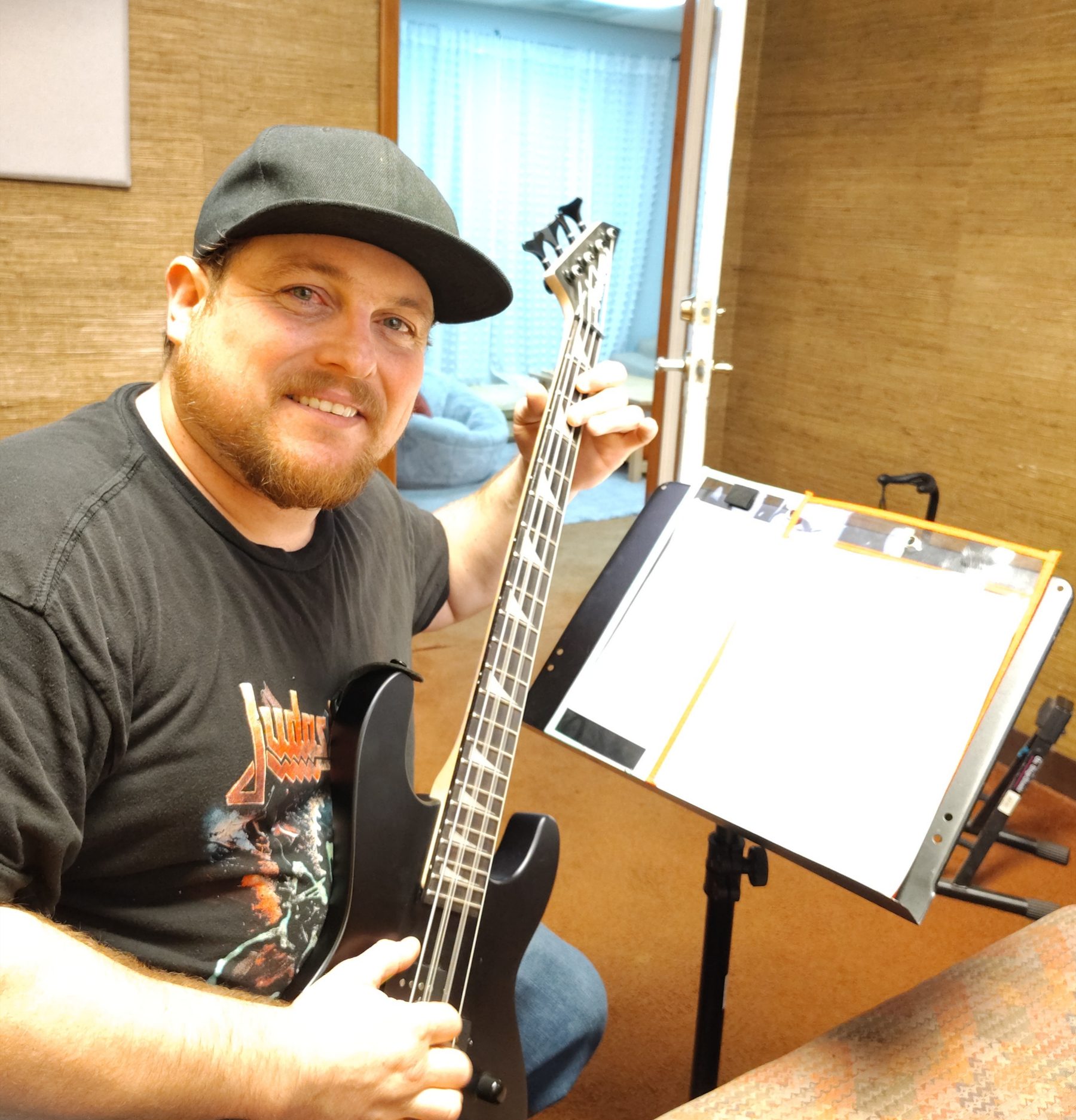 Ben Daw with a bass guitar in his Chico music lesson studio